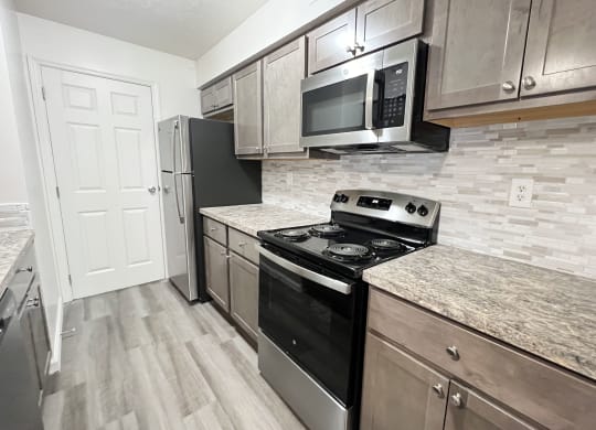 an updated kitchen with stainless steel appliances and marble counter tops  at Deercross Apartments, Ohio