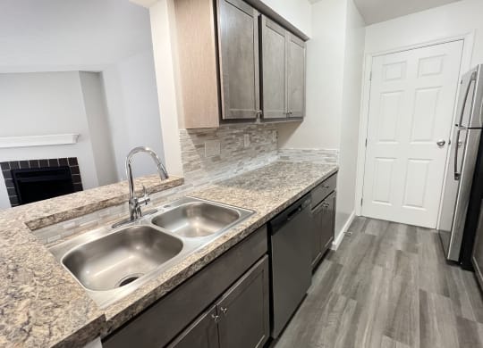 a kitchen with granite counter tops and a stainless steel sink  at Deercross Apartments, Ohio, 45236