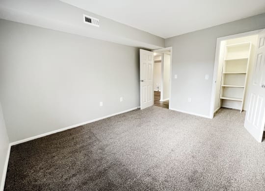 an empty bedroom with carpeting and a closet  at Deercross Apartments, Ohio