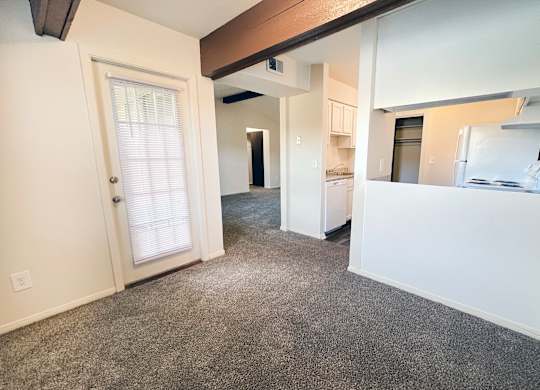 an empty living room with a door to the kitchen and a hallway to the bedroom at Four Worlds Apartments, Ohio, 45231