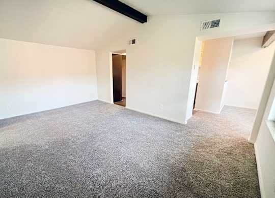an empty living room with white walls and carpet at Four Worlds Apartments, Cincinnati, Ohio