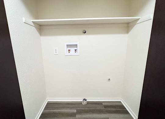 an empty room with a white wall and a door at Four Worlds Apartments, Cincinnati