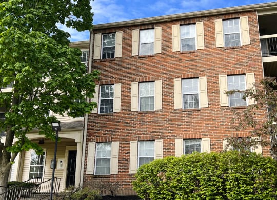 a brick apartment building with a tree in front of it  at Woodhills Apartments, West Carrollton, OH, 45449