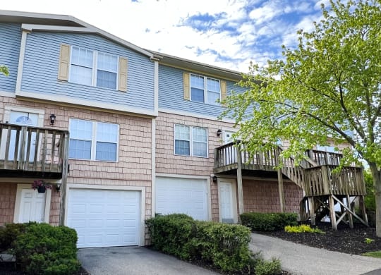 a view of a two story apartment building with two garages and a balcony  at Woodhills Apartments, West Carrollton, OH