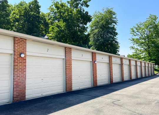 a row of white garage doors on a brick wall