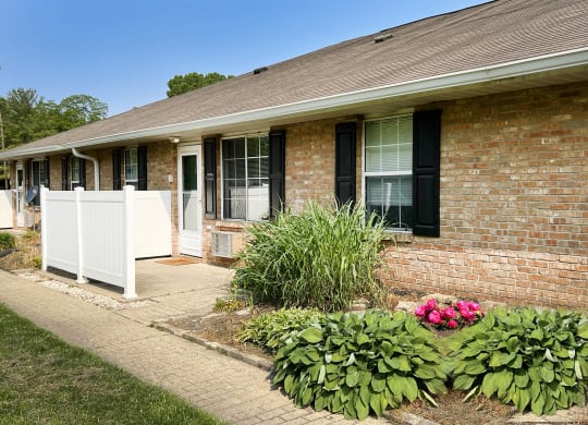 a white fence in front of a brick building  at Wyndemere Apartments, Ohio, 45005