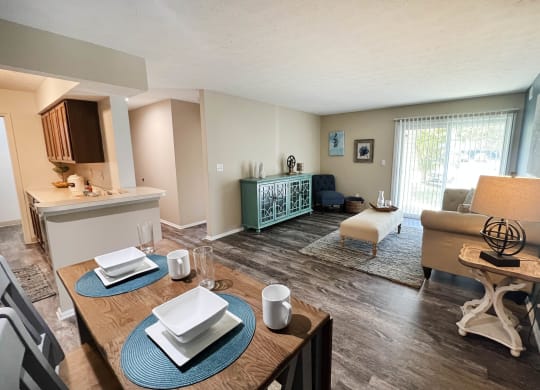a living room with a dining table and a kitchen in the background  at Steeplechase Apartments, Ohio