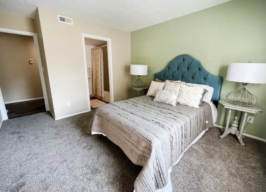 a bedroom with a bed and two lamps  at Steeplechase Apartments, Loveland, 45140