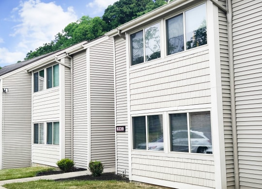 a white building with white siding and green shutters  at Hunter's Creek Apartments, Ohio