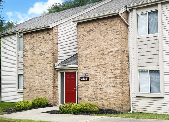 a brick building with a red door and a white siding  at Hunter's Creek Apartments, Cincinnati, 45242