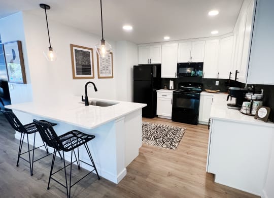 a kitchen with white cabinets and black appliances at Indian Lookout Apartments, Cincinnati, OH