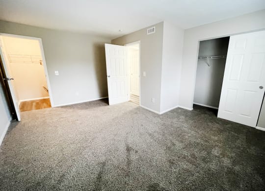 an empty bedroom with a closet and a door open at Crown Ridge Apartments, Franklin