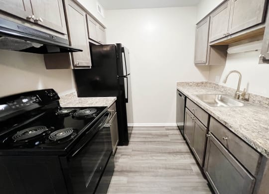 a kitchen with white cabinets and black appliances at Crown Ridge Apartments, Ohio