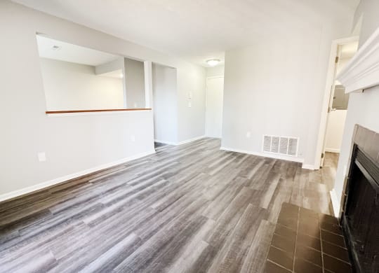 the living room and dining room of an apartment with wood flooring  at Deercross Apartments, Ohio