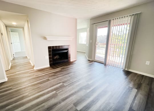 an empty living room with a fireplace and a sliding glass door  at Deercross Apartments, Ohio, 45236