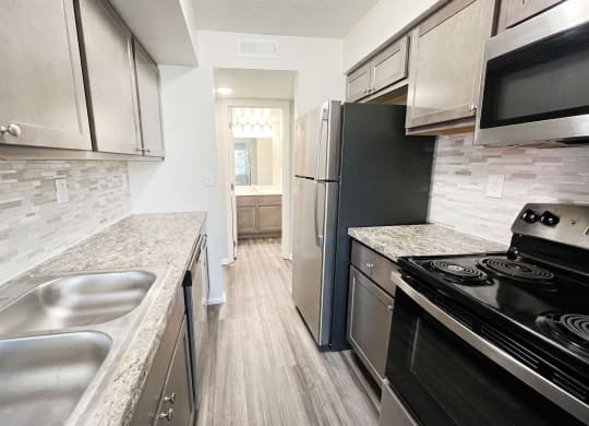 a kitchen with stainless steel appliances and marble counter tops  at Deercross Apartments, Ohio, 45236