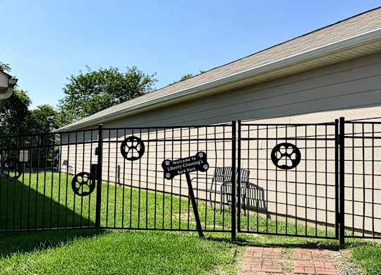 A black metal fence with a mailbox and a wheel design on it.