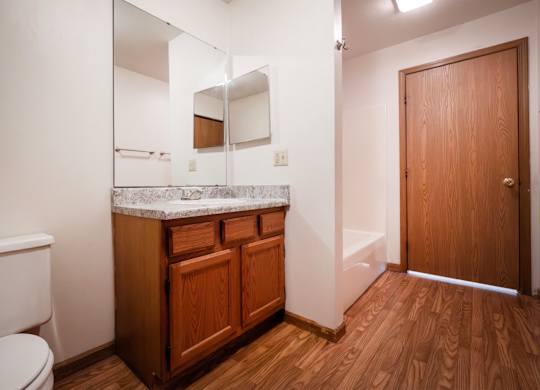A bathroom with wooden cabinets and a white toilet.