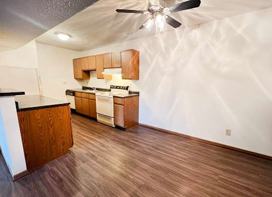 the view of a kitchen and living room with wood flooring and a ceiling fan at Forest Creek Apartments, Middletown, OH 45044