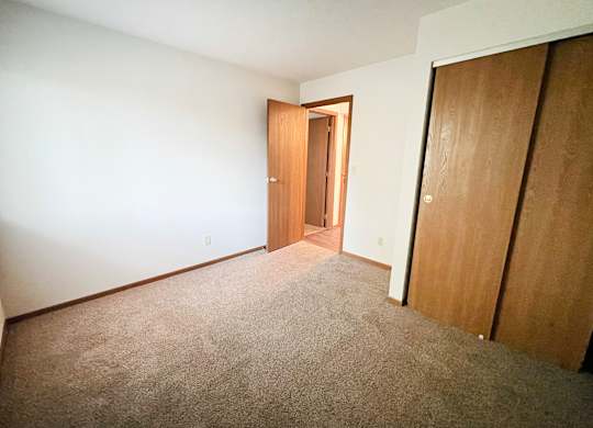 a bedroom with a carpeted floor and a door to a closet at Forest Creek Apartments, Middletown, 45044