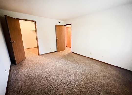 an empty room with a carpeted floor and two doors at Forest Creek Apartments, Middletown, OH