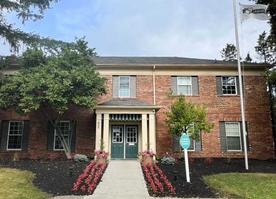 a brick building with a green door and a street sign