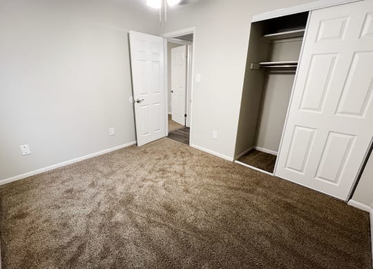 an empty bedroom with a carpeted floor and a closet at Crown Court Apartments, Florence