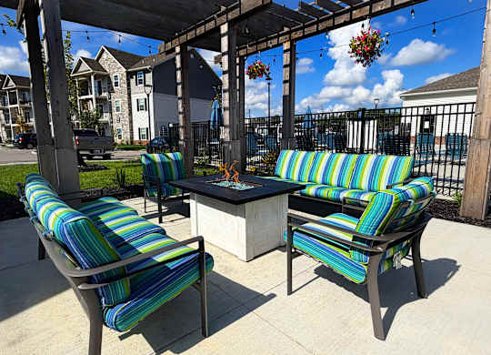 Two striped chairs and a table are on a patio.