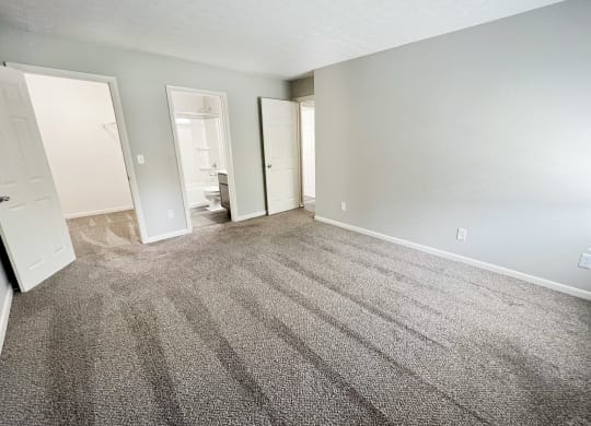 an empty living room with gray carpet and white walls at Fox Run Apartments, Cincinnati, OH