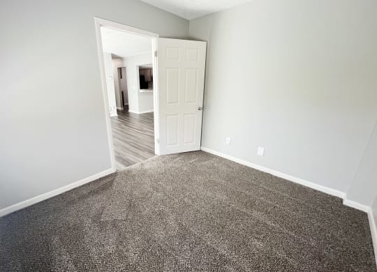 an empty living room with carpet and a door to a bedroom at Fox Run Apartments, Cincinnati, OH, 45236