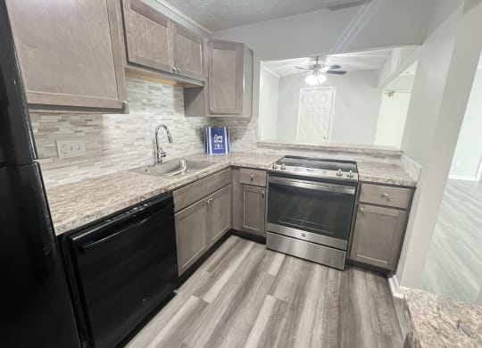 an empty kitchen with stainless steel appliances and wooden cabinets at Fox Run Apartments, Cincinnati, OH, 45236