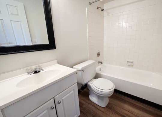 an empty bathroom with a toilet and a tub and a sink  at Crown Station Apartments, Amelia, OH, 45102