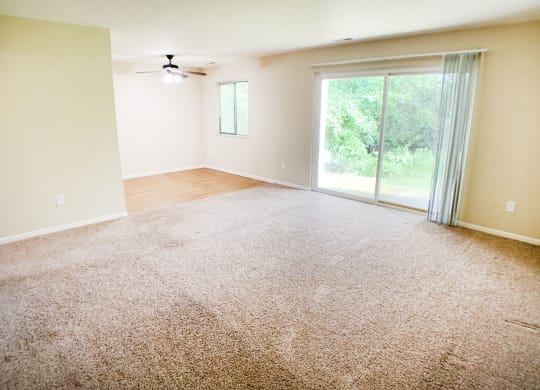 an empty living room with carpet and a sliding glass door  at Hunter's Creek Apartments, Ohio, 45242