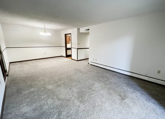 the living room of an empty house with white walls and a concrete floor