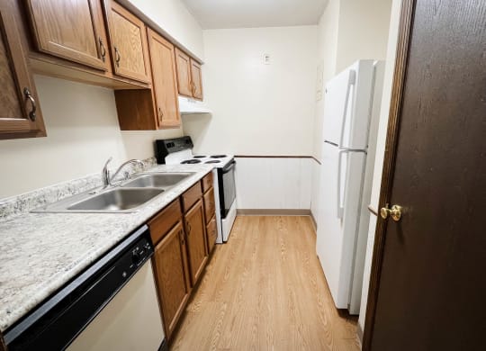 an empty kitchen with a sink and a refrigerator