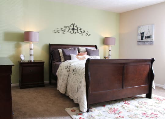 a bedroom with a bed and two lamps  at Hunter's Creek Apartments, Ohio, 45242