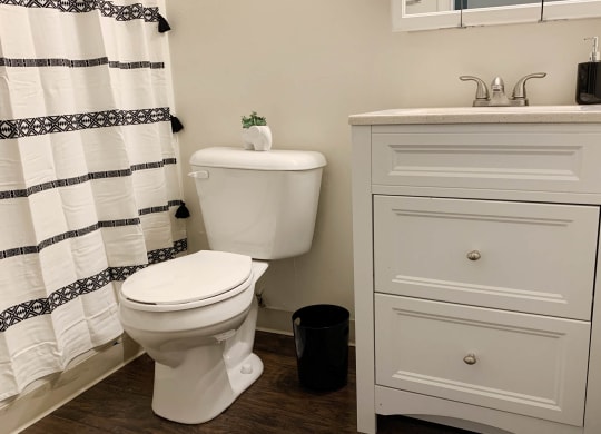 a bathroom with a toilet and a sink  at Timber Ridge Apartments, Cincinnati, Ohio