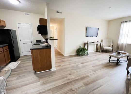 an open living room and kitchen with wood flooring and a tv at Residences at Northgate Crossing, Ohio, 43235
