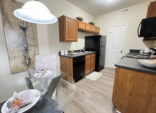 an open kitchen and dining room with a glass table and chairs at Residences at Northgate Crossing, Ohio, 43235