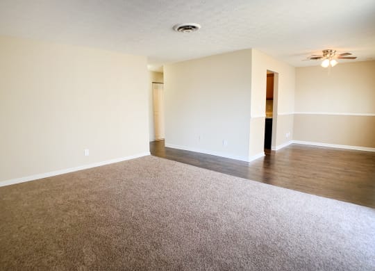 an empty living room with carpet and a ceiling fan  at Timber Ridge Apartments, Cincinnati