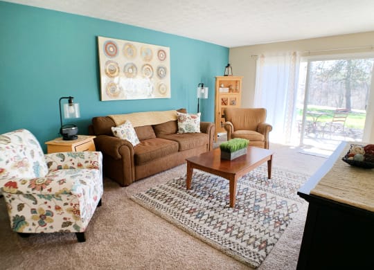 a living room with a couch and a chair and a table at Timber Ridge Apartments, Cincinnati