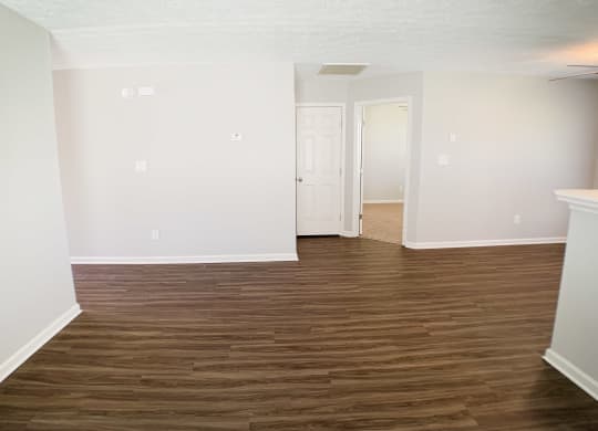 an empty living room with wood flooring and white walls  at Aberdine Place, Kentucky