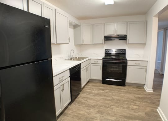 an empty kitchen with white cabinets and black appliances  at Knobs Pointe Apartments, New Albany, IN