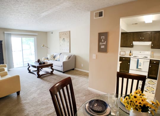 an open living room and kitchen with a table and chairs at Knobs Pointe Apartments, New Albany