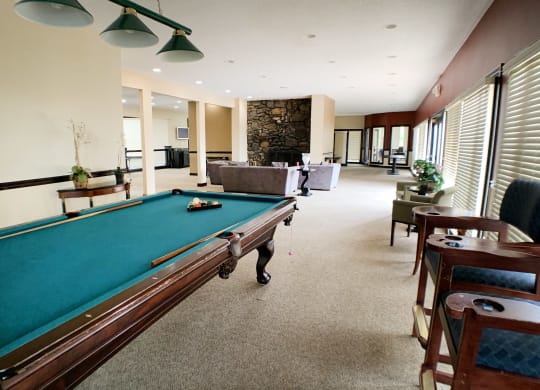 a large living room with a pool table  at Knobs Pointe Apartments, New Albany