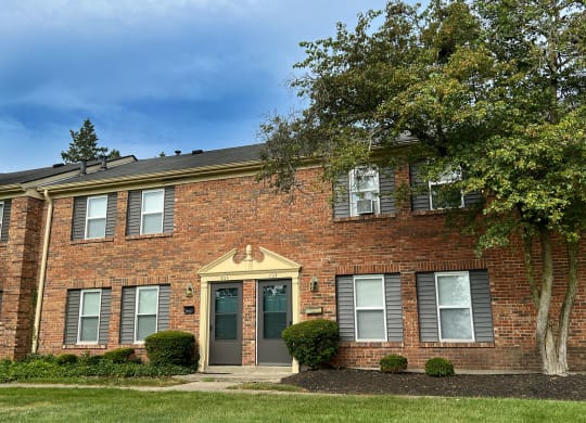 a brick house with a tree in front of it at Revere Village Apartments, Centerville, 45458