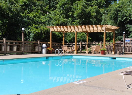 a swimming pool with a wooden canopy next to a resort pool at The Vinings Apartments, Cincinnati, 45245