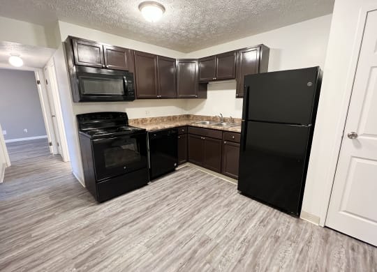 a kitchen with a black refrigerator freezer and a black stove top oven at Quail Meadow Apartments, Cincinnati, OH, 45240