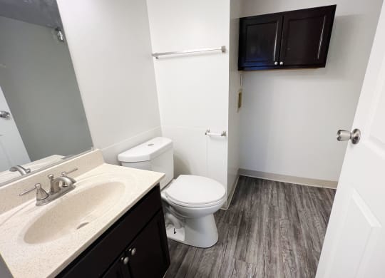 a bathroom with a toilet sink and mirror at Quail Meadow Apartments, Cincinnati, 45240