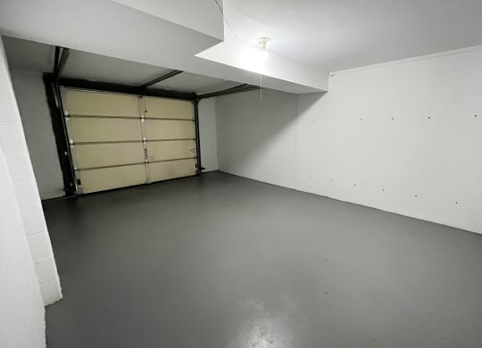 an empty room with a garage door in the corner